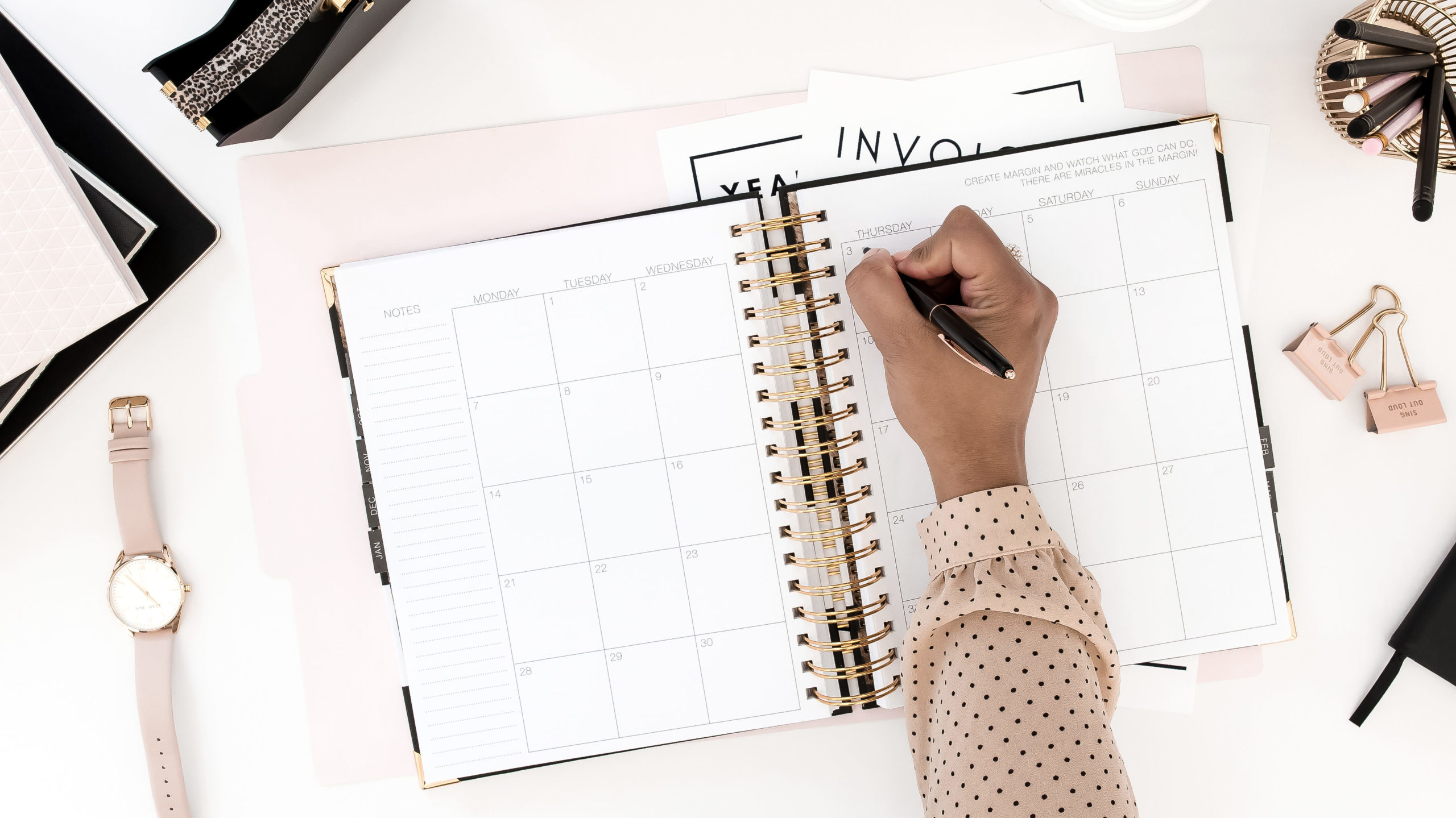 Frau führt einen Redaktionsplan und schreibt etwas in ihren Kalender